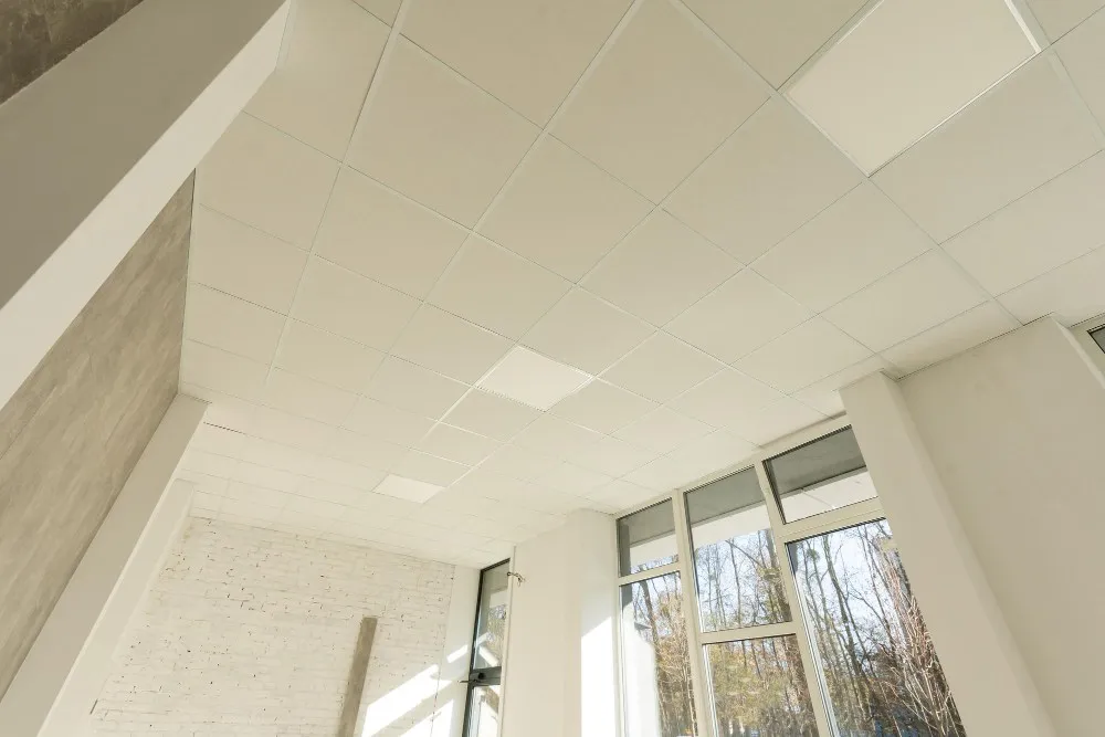 Plafond suspendu en dalles de polystyrène blanc.